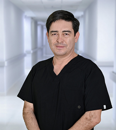 Es la foto de perfil de un biólogo de reproducción, ginecólogo y obstetra en Ciudad Juárez de Hospital Angeles Ciudad Juárez. Usa un uniforme azul marino, cabello oscuro y está sonriendo. 