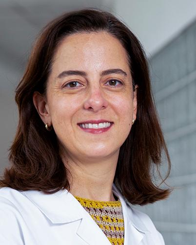 Es la foto de perfil de un especialista en medicina de rehabilitación en Huixquilucan. Tiene el cabello corto café. Usa una bata blanca y un suéter amarillo.