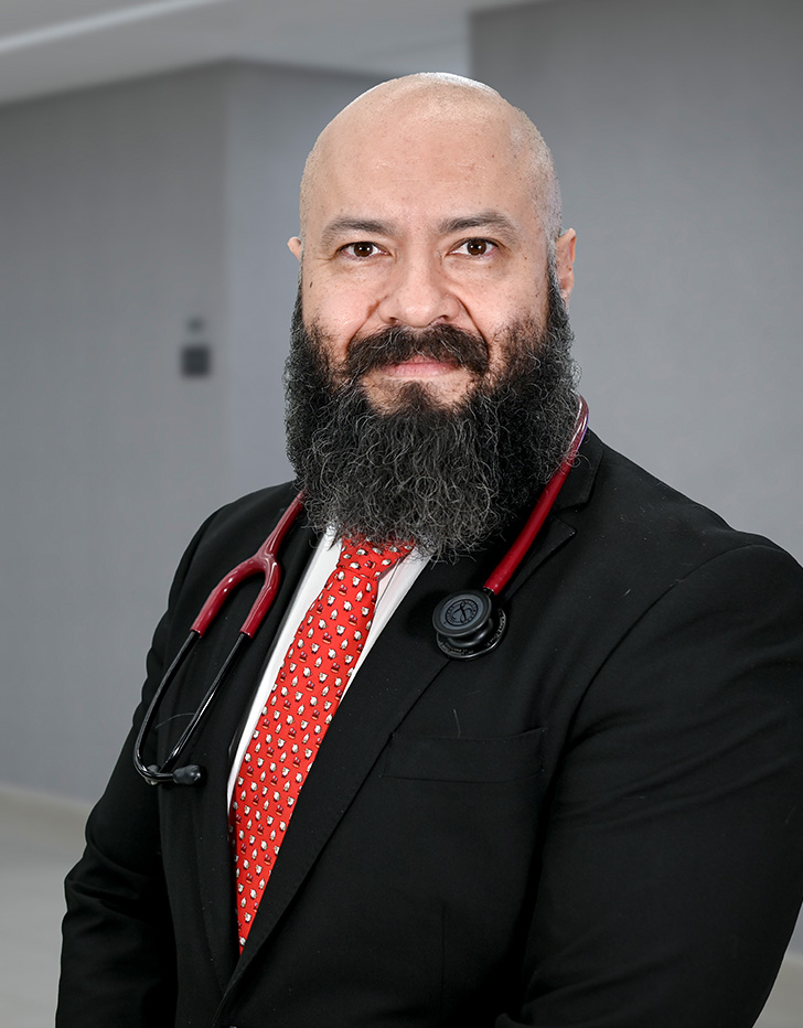 Es la foto de perfil de un endoscopista especialista en gastroenterología en Ciudad de México de Hospital Angeles Lindavista. Es calvo, tiene una barba y bigote negro. 
