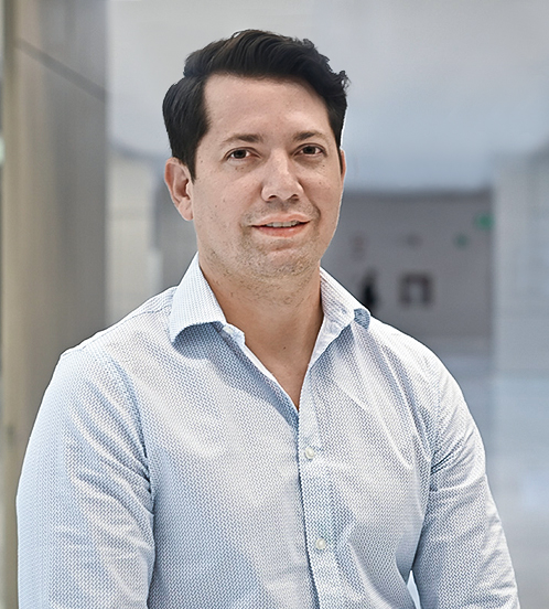 Es la foto de perfil de un cirujano oncológico en Querétaro de Hospital Angeles Centro Sur. Usa una camisa blanca, tiene el cabello negro y está sonriendo.