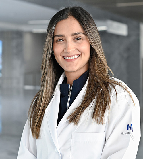 Es la foto de perfil de una nutrióloga en Querétaro de Hospital Angeles Centro-sur. Usa una chamarra azul oscuro y por encima tiene una bata blanca. Tiene el cabello café con rayos rubios. Está sonriendo.