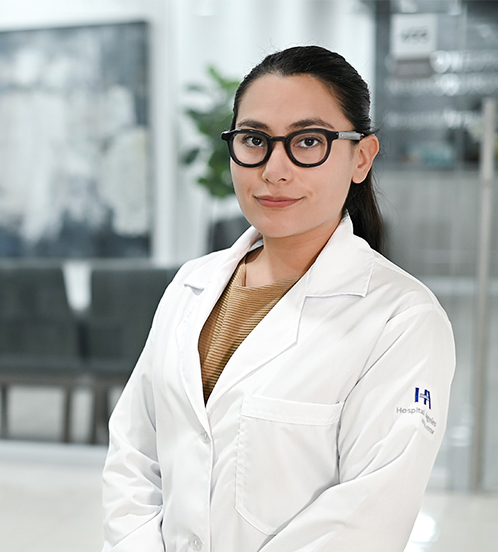 Es la foto de perfil de una ortopedista y traumatóloga en Ciudad de México de Hospital Angeles Acoxpa. Usa una bata blanca con una blusa café claro. Tiene el cabello recogido y usa lentes de armazón negro y grueso.