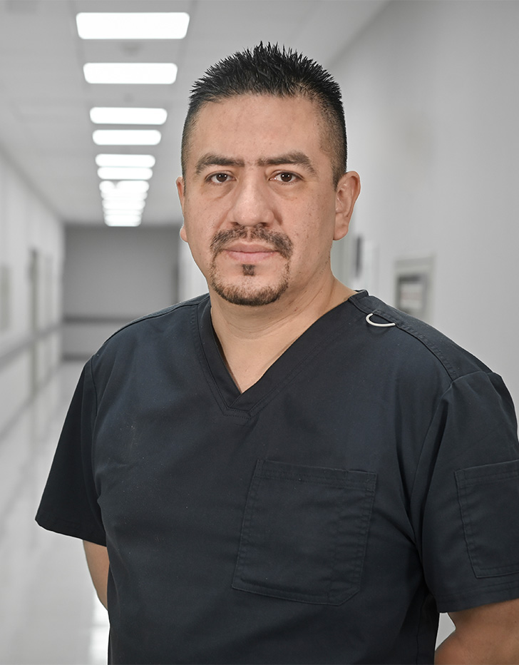 Es la foto de perfil de un cirujano oncológico y cirujano general en Ciudad de México de Hospital Angeles Universidad. Usa un uniforme médico negro. Tiene el cabello y barba negra. Tiene los brazos cruzados por la parte de atrás.